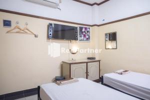 Postel nebo postele na pokoji v ubytování Athaya Hotel Syariah near UGM Yogyakarta Mitra RedDoorz