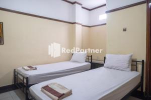 Postel nebo postele na pokoji v ubytování Athaya Hotel Syariah near UGM Yogyakarta Mitra RedDoorz