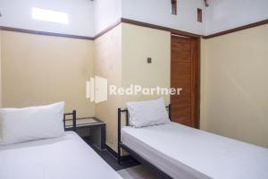 Postel nebo postele na pokoji v ubytování Athaya Hotel Syariah near UGM Yogyakarta Mitra RedDoorz