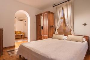 ein Schlafzimmer mit einem Bett und einem großen Fenster in der Unterkunft Family Hotel Bile in Beli Osam