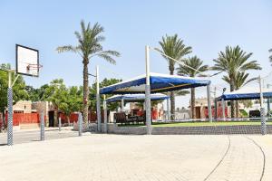 einem Basketballplatz mit blauem Baldachin und einem Basketballkorb in der Unterkunft OYO 138 Gulf Sand Motel in Barka