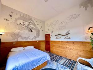 滿州鄉的住宿－Wild East Country House，卧室配有一张床,墙上挂有绘画作品