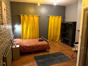 a room with yellow curtains and a bed in it at Top Floor in Lincoln