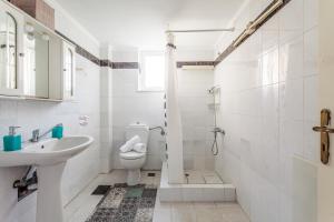 a white bathroom with a sink and a toilet at Koroni Seaview Retreats - Summer Escape Lodgings in Koroni