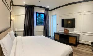 - une chambre avec un grand lit et une télévision dans l'établissement Khách sạn Robin Gia Nghĩa, à Gia Nghĩa