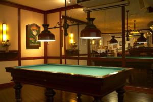 a pool table in a room with pendant lights at Hotel Hof van Gelre by Flow in Lochem