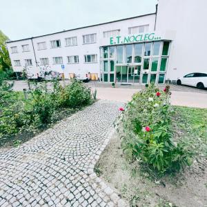 un bâtiment avec un chemin en briques devant un bâtiment dans l'établissement ET Nocleg, à Kalisz