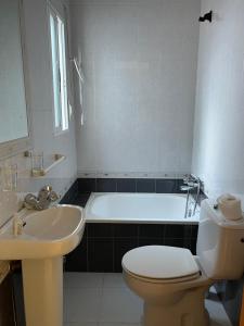 een badkamer met een bad, een toilet en een wastafel bij Pensión Coripe in Coripe