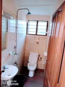 łazienka z toaletą i umywalką w obiekcie Akwa Guesthouse Cotonou w mieście Kotonu