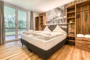 a bedroom with a bed and a large window at Brandnerhus by A-Appartments in Brand