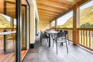 a dining room with a table and chairs on a balcony at Brandnerhus by A-Appartments in Brand