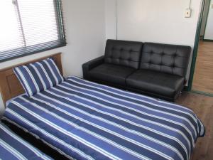 a bedroom with a bed and a couch at Fukuoka - House / Vacation STAY 4617 in Fukuoka