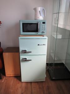 a microwave sitting on top of a refrigerator at Fukuoka - House / Vacation STAY 4617 in Fukuoka