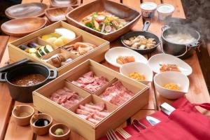 una mesa cubierta con cajas de comida y tazones de comida en GRAND VERDE RESORT, en Kamegawa