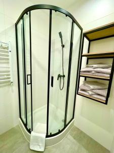 a shower with a glass enclosure in a bathroom at Pokoje gościnne - Kasztelańska 8 in Stara Kamienica