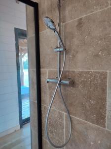 eine Dusche mit Duschkopf im Bad in der Unterkunft Le Domaine des Roches' L in Gommené