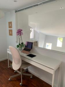 einen weißen Schreibtisch mit einem Laptop und einem Stuhl in der Unterkunft La Postoca in Viavélez