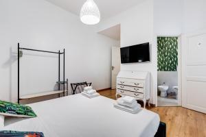 a white bedroom with two beds and a tv at BDC - Residenza Valadier 3-Bdr and 3 bathrooms apt in Rome