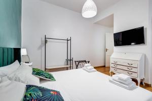 a bedroom with a white bed and a dresser and a tv at BDC - Residenza Valadier 3-Bdr and 3 bathrooms apt in Rome