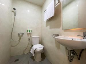 La salle de bains est pourvue d'un lavabo, de toilettes et d'une douche. dans l'établissement LEAF HoteL, à Jakarta