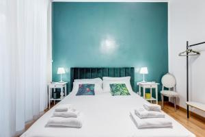 a bedroom with a large white bed with blue walls at BDC - Residenza Valadier 3-Bdr and 3 bathrooms apt in Rome
