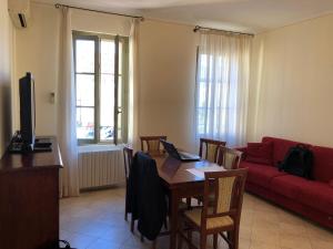 ein Wohnzimmer mit einem Tisch und einem roten Sofa in der Unterkunft Centro Paolo VI in Brescia