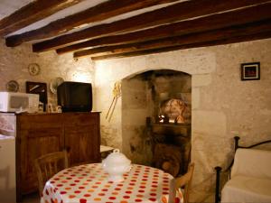 a dining room with a table and a television and a table and chairs at Maison familiale paisible proche de Braslou + jardin spacieux in Braslou