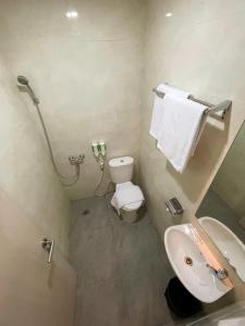 a small bathroom with a toilet and a sink at LEAF HoteL in Jakarta