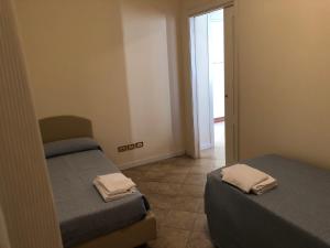 a small room with two beds and a doorway at Centro Paolo VI in Brescia