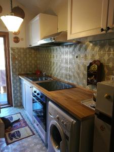 a kitchen with a washer and a sink and a stove at Cogne come una volta in Cogne
