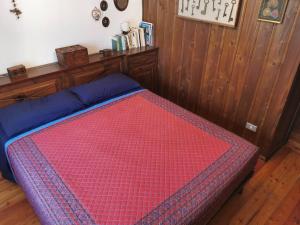 a bedroom with a bed with a red comforter at Cogne come una volta in Cogne