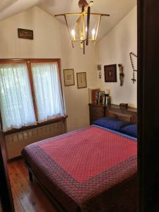 Schlafzimmer mit einem Bett mit einer roten Bettdecke in der Unterkunft Cogne come una volta in Cogne