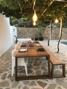 a wooden table with white chairs and a dining room at Casa Olivo in Iznájar