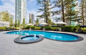 einen Pool mit Stühlen und ein Gebäude in der Unterkunft Spacious & Magnificent Views Apartment in Gold Coast