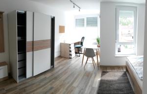 een slaapkamer met een bed, een bureau en een tafel bij Business Apartments Heilbronn in Heilbronn