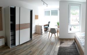 a bedroom with a bed and a desk and a table at Business Apartments Heilbronn in Heilbronn