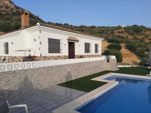 eine Villa mit einem Pool vor einem Haus in der Unterkunft Vivienda Rural Villa Madrid Alcázar in El Gastor