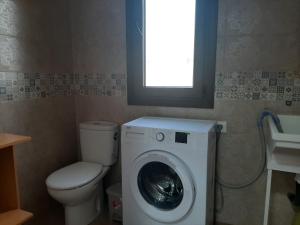 een badkamer met wasmachine en toilet bij Vivienda Rural Villa Madrid Alcázar in El Gastor