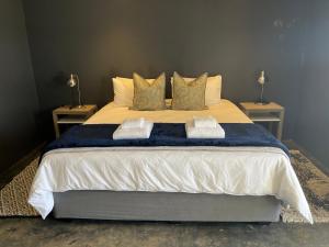 a bedroom with a large bed with two tables at The Capri Green in Knysna