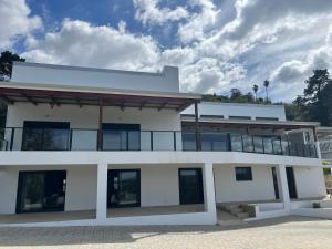 a white building with windows and a cloudy sky at The Capri Green in Knysna