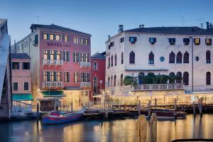 a group of buildings next to a canal with boats at NH Venezia Santa Lucia in Venice