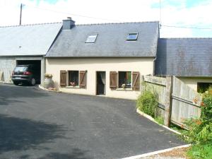 a house with a car parked next to a driveway at La ferme de la Cavalerie in Saint-Gonnery