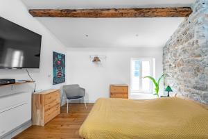 1 dormitorio con 1 cama grande y TV en Singulary House-Loft with AC Downtown - Dodo et Tartine, en Hyères