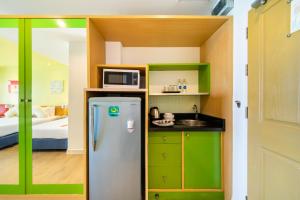 a small kitchen with a refrigerator and a bed at Best Bella Pattaya in North Pattaya