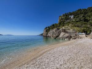 a beach with a rocky shore and the ocean at Apartment Rea with Pool in Brseč