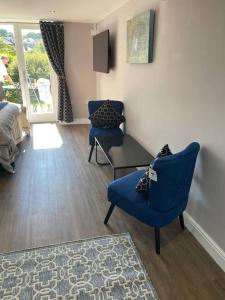 a room with two chairs and a table and a bed at Immaculate 1-Bed Studio with outside patio in Brighouse