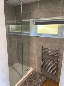a shower with a glass door in a bathroom at Immaculate 1-Bed Studio with outside patio in Brighouse