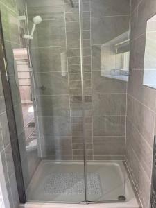 La salle de bains est pourvue d'une douche avec une porte en verre. dans l'établissement Immaculate 1-Bed Studio with outside patio, à Brighouse