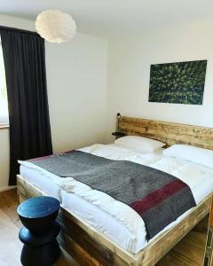 a bedroom with a large bed with a wooden headboard at Feldberg Apartment - direkt an der Skipiste - mit Sauna in Feldberg