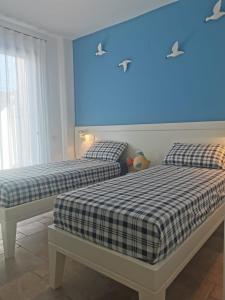 two beds in a room with a blue light at Villa Bravo in Karpathos Town